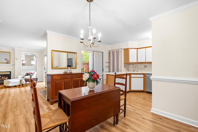 320 Summerwalk Cir, Chapel Hill, NC 27517 - dining room with a chandelier, light wood finished floors, ornamental molding, a glass covered fireplace, and baseboards