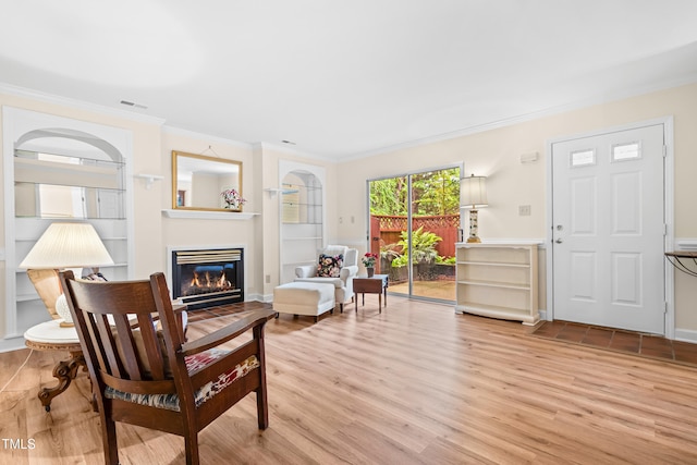 320 Summerwalk Cir, Chapel Hill, NC 27517 - living room featuring a glass covered fireplace, ornamental molding, light wood-style floors, and built in features