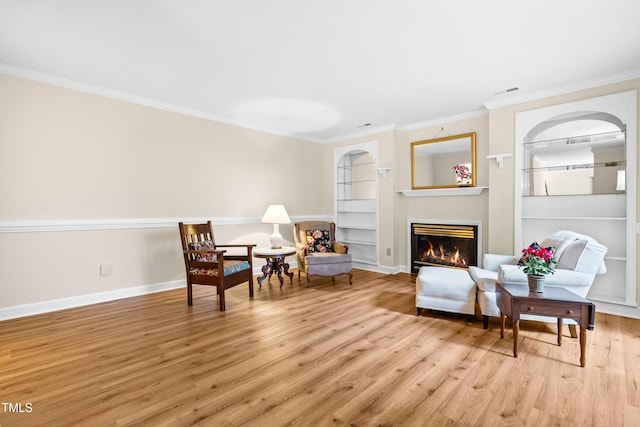 320 Summerwalk Cir, Chapel Hill, NC 27517 - living area featuring built in shelves, light wood-style floors, a glass covered fireplace, ornamental molding, and baseboards