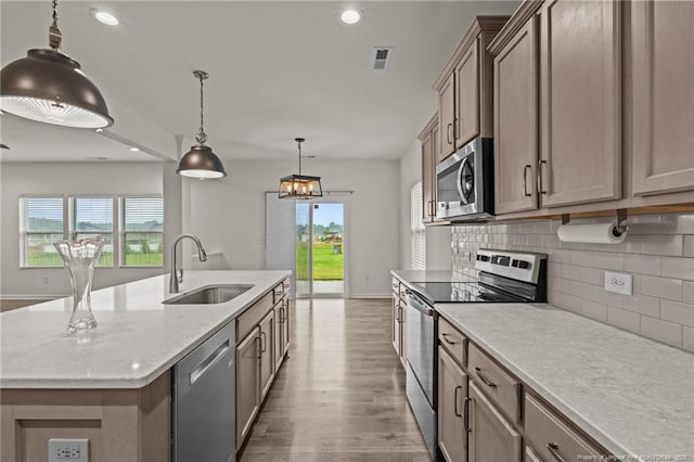 40 Arlie Ln, Lillington, NC 27546 - kitchen featuring appliances with stainless steel finishes, a sink, wood finished floors, backsplash, and plenty of natural light