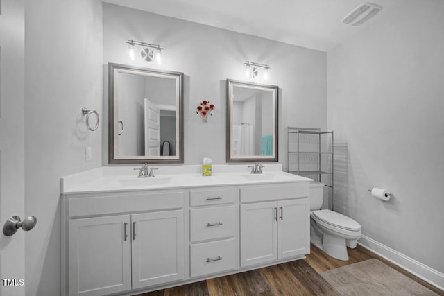 50 Harriet Gentry Ln, Timberlake, NC 27583 - bathroom featuring double vanity, toilet, wood finished floors, and baseboards