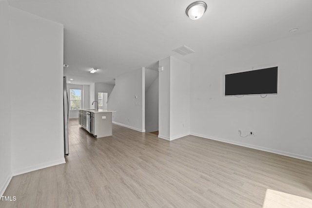 447 N Fisher St, Raleigh, NC 27610 - unfurnished living room with a sink, light wood-type flooring, and baseboards