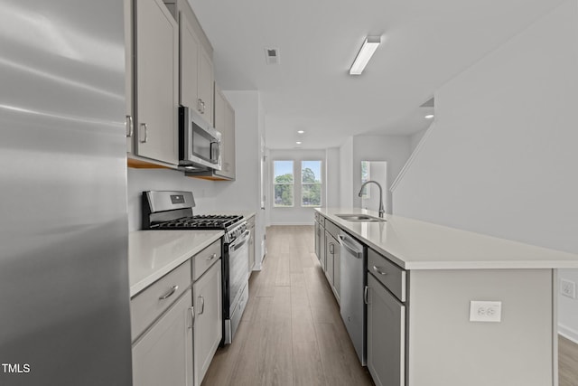 447 N Fisher St, Raleigh, NC 27610 - kitchen with appliances with stainless steel finishes, a sink, wood finished floors, light countertops, and gray cabinets