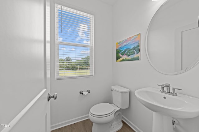447 N Fisher St, Raleigh, NC 27610 - half bathroom featuring wood finished floors, baseboards, toilet, and a sink