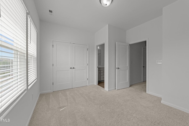 447 N Fisher St, Raleigh, NC 27610 - unfurnished bedroom with carpet, multiple windows, a closet, and baseboards