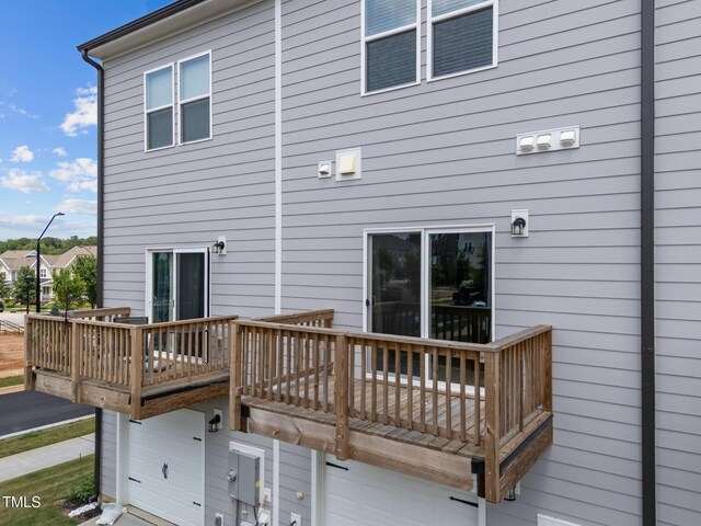 447 N Fisher St, Raleigh, NC 27610 - back of property featuring a wooden deck and an attached garage
