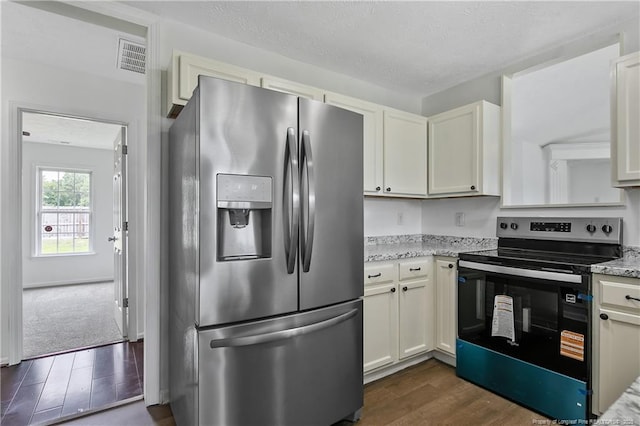120 Wood Valley Ln, Raeford, NC 29376 - kitchen with appliances with stainless steel finishes, dark wood-type flooring, light stone countertops, white cabinets, and a textured ceiling