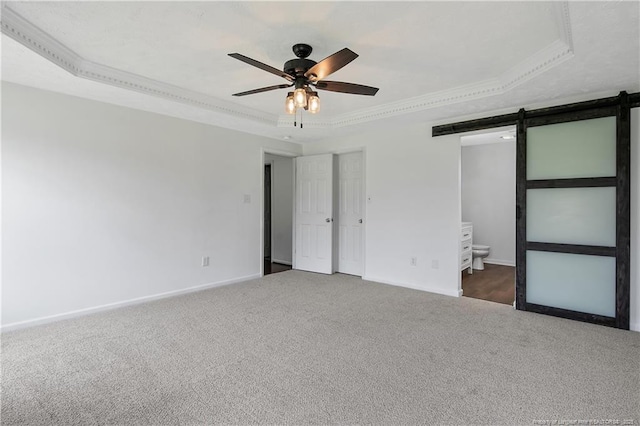 120 Wood Valley Ln, Raeford, NC 29376 - unfurnished bedroom with a raised ceiling, a barn door, carpet flooring, crown molding, and baseboards