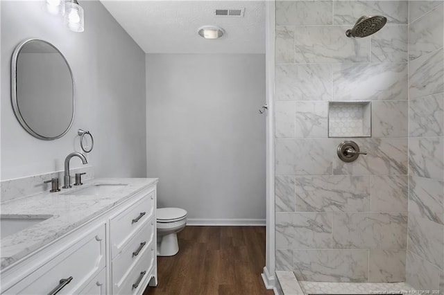 120 Wood Valley Ln, Raeford, NC 29376 - bathroom with double vanity, tiled shower, wood finished floors, toilet, and baseboards