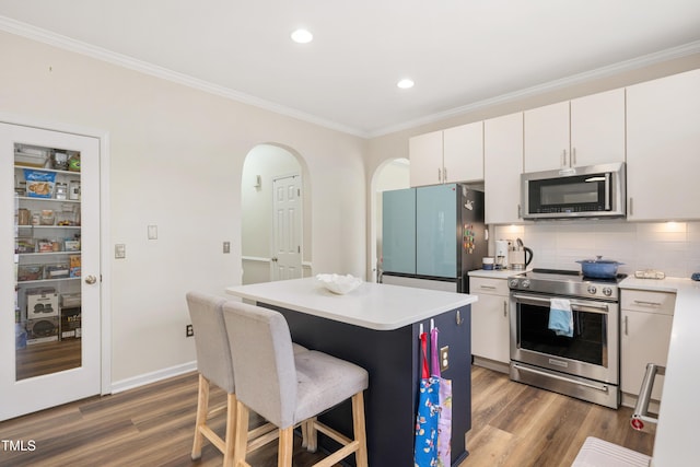930 Pristine Ln, Rolesville, NC 27571 - kitchen featuring stainless steel appliances, light countertops, ornamental molding, a center island, and backsplash