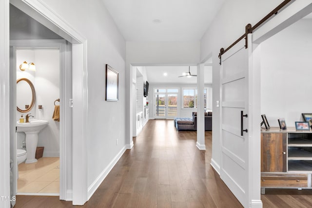 390 Lake Magnolia Way, Smithfield, NC 27577 - hallway featuring dark wood-style floors, a barn door, and baseboards