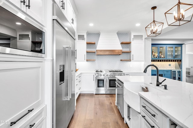 390 Lake Magnolia Way, Smithfield, NC 27577 - kitchen featuring high end appliances, custom exhaust hood, open shelves, a chandelier, and white cabinetry