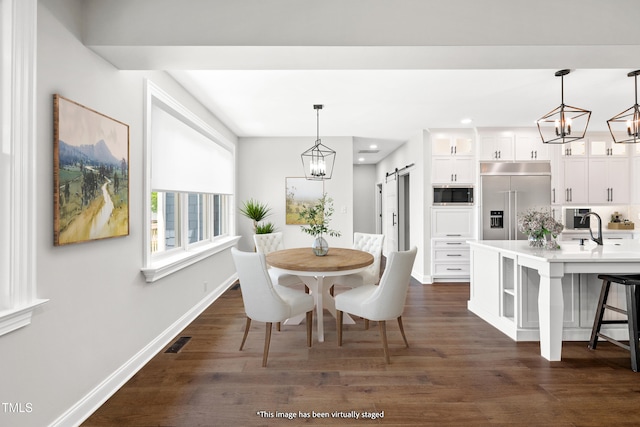 390 Lake Magnolia Way, Smithfield, NC 27577 - dining room with a barn door, dark wood-type flooring, baseboards, recessed lighting, and a chandelier