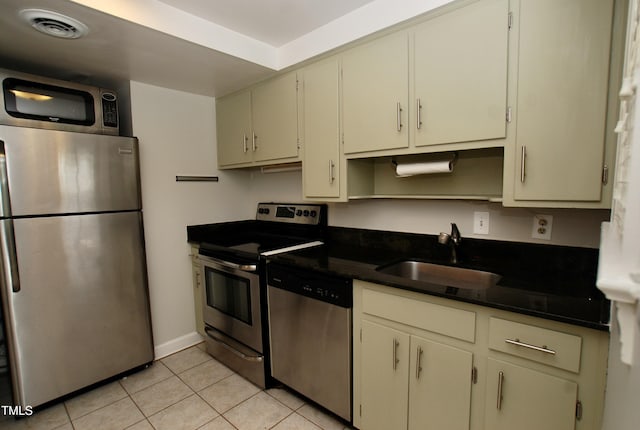 1908 Smallwood Dr, Raleigh, NC 27605 - kitchen featuring stainless steel appliances, a sink, light tile patterned flooring, baseboards, and dark stone countertops