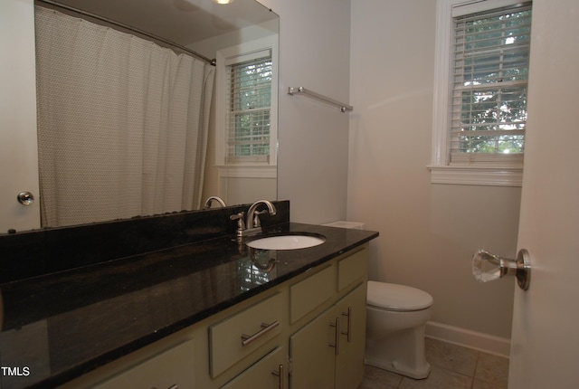 1908 Smallwood Dr, Raleigh, NC 27605 - bathroom with vanity, toilet, tile patterned floors, baseboards, and plenty of natural light