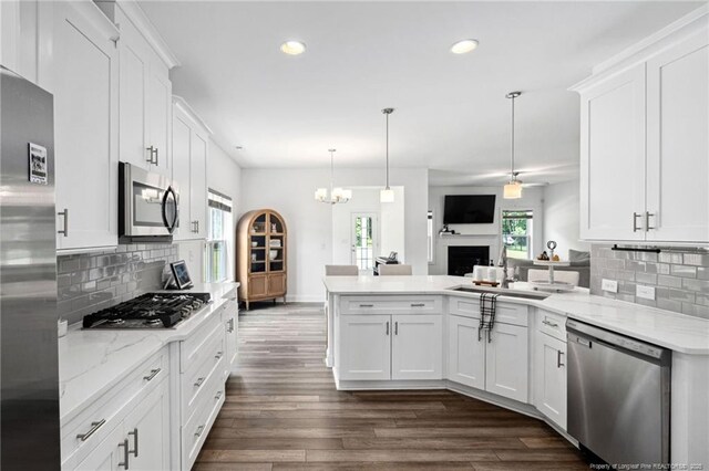 25 Vast View Way, Youngsville, NC 27596 - kitchen with stainless steel appliances, a peninsula, white cabinetry, a sink, and dark wood-type flooring