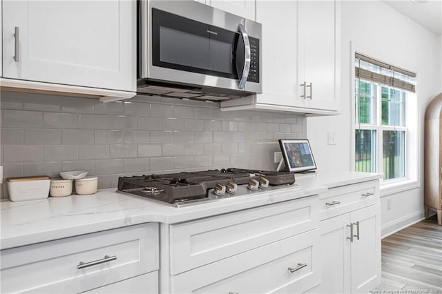 25 Vast View Way, Youngsville, NC 27596 - kitchen with stainless steel appliances, white cabinets, light stone counters, and backsplash