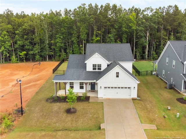 25 Vast View Way, Youngsville, NC 27596 - modern farmhouse with board and batten siding, a garage, concrete driveway, a porch, and central air condition unit