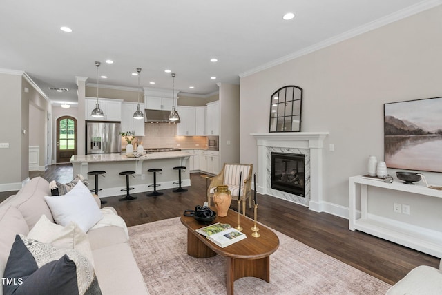 728 Peninsula Forest Pl, Cary, NC 27519 - living room featuring crown molding, dark wood-style flooring, a fireplace, and recessed lighting