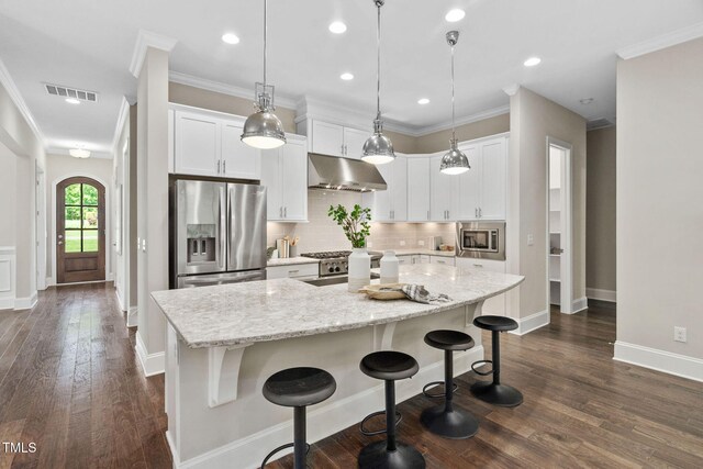 728 Peninsula Forest Pl, Cary, NC 27519 - kitchen featuring appliances with stainless steel finishes, under cabinet range hood, a center island, decorative backsplash, and white cabinets