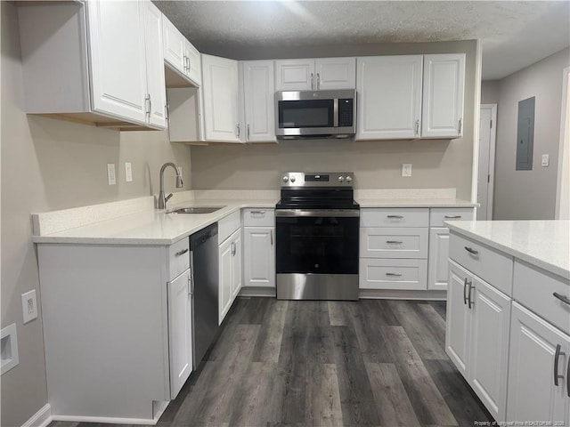 2903 Peacock St, Hope Mills, NC 28348 - kitchen with stainless steel appliances, a sink, white cabinetry, dark wood-style floors, and light countertops