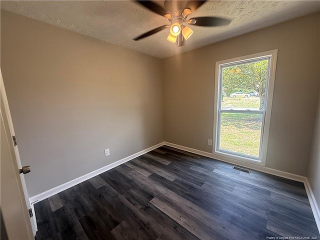 2903 Peacock St, Hope Mills, NC 28348 - unfurnished room with a textured ceiling, baseboards, dark wood finished floors, and ceiling fan