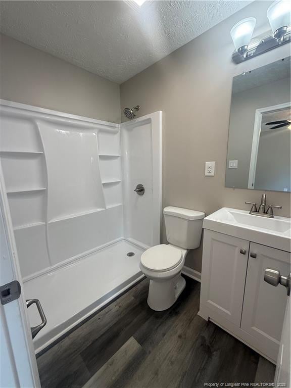 2903 Peacock St, Hope Mills, NC 28348 - full bathroom featuring toilet, wood finished floors, vanity, a shower, and a textured ceiling
