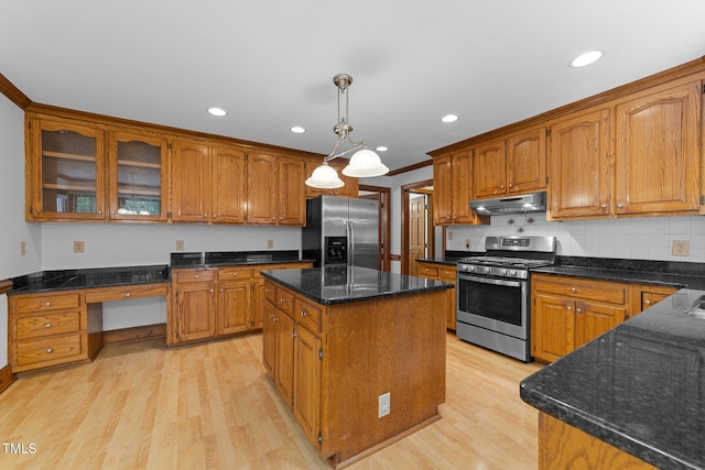 221 Jansmith Ln, Raleigh, NC 27615 - kitchen featuring appliances with stainless steel finishes, under cabinet range hood, light wood-style floors, brown cabinets, and a center island