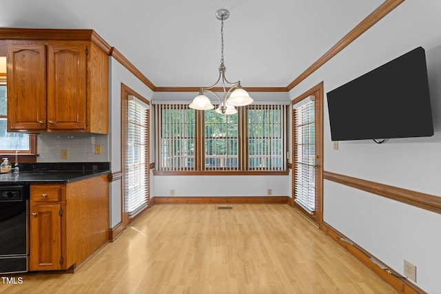 221 Jansmith Ln, Raleigh, NC 27615 - kitchen with light wood-style floors, black dishwasher, a chandelier, baseboards, and brown cabinetry