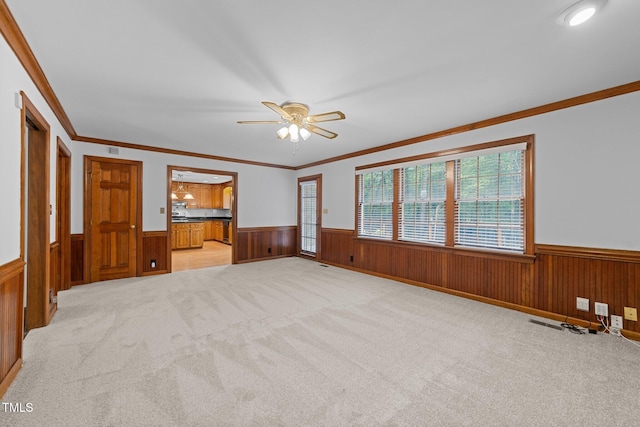 221 Jansmith Ln, Raleigh, NC 27615 - unfurnished living room featuring wainscoting, a ceiling fan, light colored carpet, ornamental molding, and wood walls