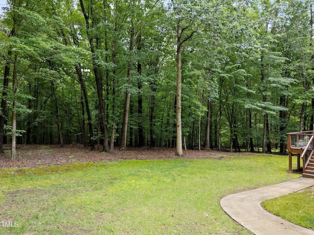 221 Jansmith Ln, Raleigh, NC 27615 - view of grassy yard featuring stairway, a wooden deck, and a view of trees
