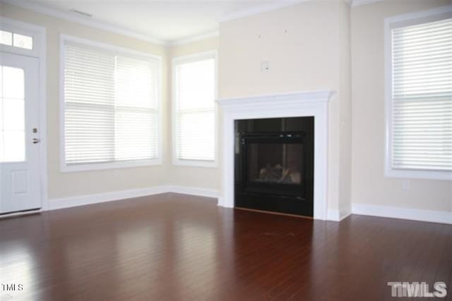 921 Rosepine Dr, Cary, NC 27519 - unfurnished living room with crown molding, wood finished floors, baseboards, plenty of natural light, and a glass covered fireplace