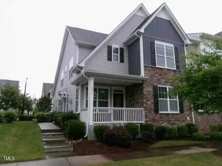 921 Rosepine Dr, Cary, NC 27519 - view of front of home featuring covered porch, stone siding, board and batten siding, and a front yard