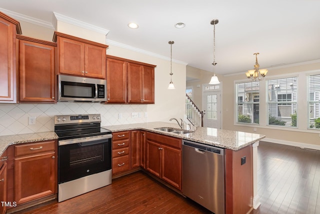 921 Rosepine Dr, Cary, NC 27519 - kitchen featuring appliances with stainless steel finishes, dark wood-style floors, ornamental molding, a peninsula, and a chandelier