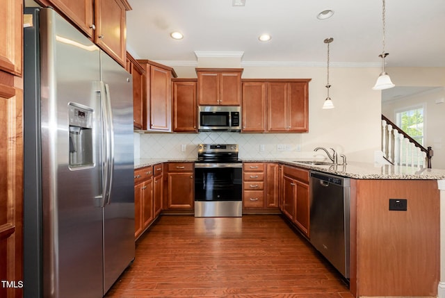 921 Rosepine Dr, Cary, NC 27519 - kitchen with stainless steel appliances, a peninsula, ornamental molding, dark wood-type flooring, and brown cabinets