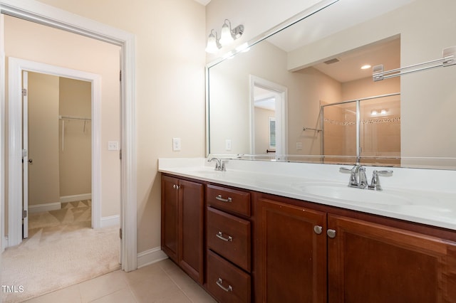 921 Rosepine Dr, Cary, NC 27519 - bathroom with double vanity, a spacious closet, tiled shower, and tile patterned floors