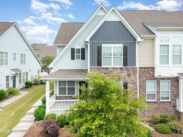 921 Rosepine Dr, Cary, NC 27519 - view of front of house with board and batten siding, a shingled roof, and stone siding