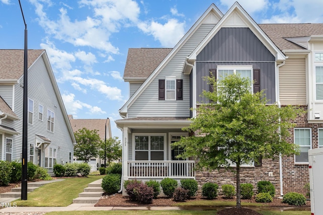 921 Rosepine Dr, Cary, NC 27519 - view of front facade featuring board and batten siding, roof with shingles, and a porch