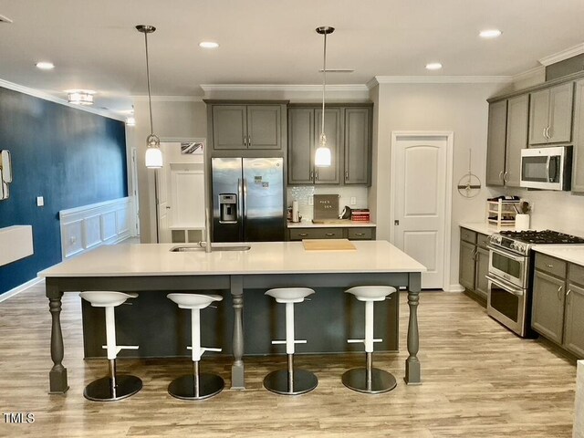 166 Gulley Glen Dr, Garner, NC 27529 - kitchen with stainless steel appliances, light wood-style floors, a kitchen breakfast bar, ornamental molding, and a kitchen island with sink