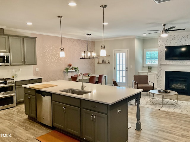 166 Gulley Glen Dr, Garner, NC 27529 - kitchen featuring stainless steel appliances, a sink, open floor plan, a kitchen island with sink, and a ceiling fan