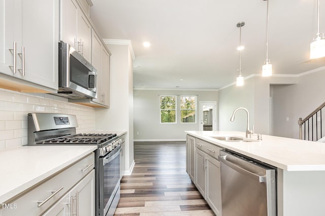 591 Traditions Grande Blvd, Wake Forest, NC 27587 - kitchen with stainless steel appliances, a sink, crown molding, light wood-type flooring, and light countertops