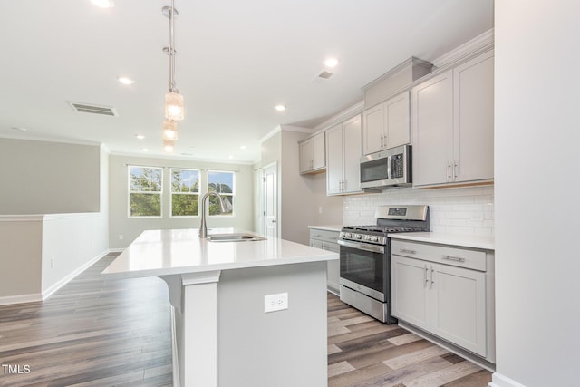 591 Traditions Grande Blvd, Wake Forest, NC 27587 - kitchen with appliances with stainless steel finishes, a sink, light wood-type flooring, decorative backsplash, and ornamental molding