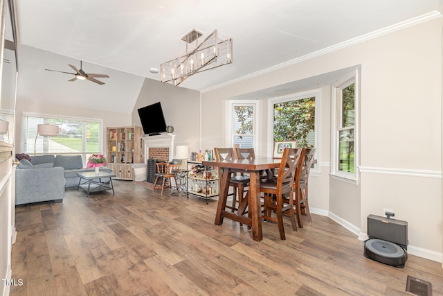 1426 Cedar Branch Ct, Wake Forest, NC 27587 - dining space with wood finished floors, ceiling fan, baseboards, a brick fireplace, and vaulted ceiling
