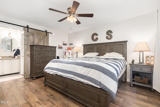 1426 Cedar Branch Ct, Wake Forest, NC 27587 - bedroom featuring wood finished floors, a barn door, a ceiling fan, and ensuite bathroom