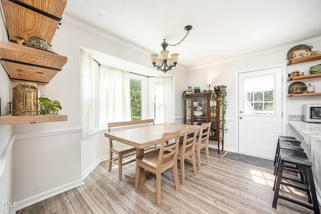 701 Creekside Dr, Clayton, NC 27520 - dining room featuring a chandelier, light wood finished floors, ornamental molding, and baseboards
