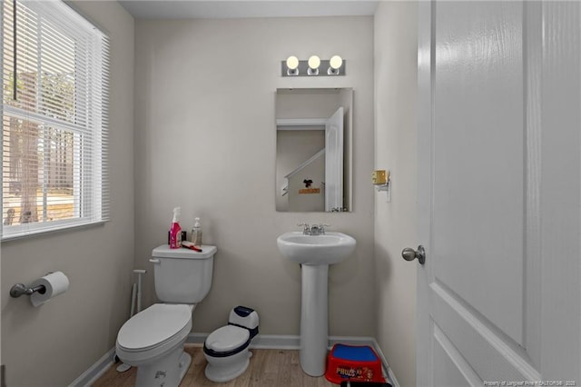 259 Desert Orchid Cir, Raeford, NC 28376 - half bathroom featuring toilet, baseboards, wood finished floors, and a sink
