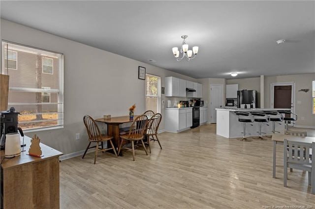259 Desert Orchid Cir, Raeford, NC 28376 - dining space with light wood-style floors, plenty of natural light, a chandelier, and baseboards