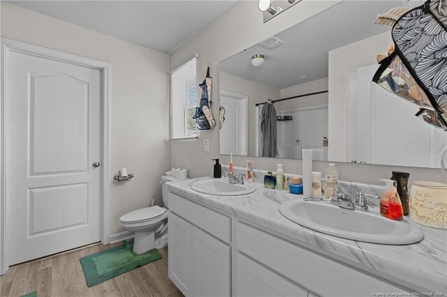 259 Desert Orchid Cir, Raeford, NC 28376 - bathroom featuring double vanity, wood finished floors, toilet, and curtained shower