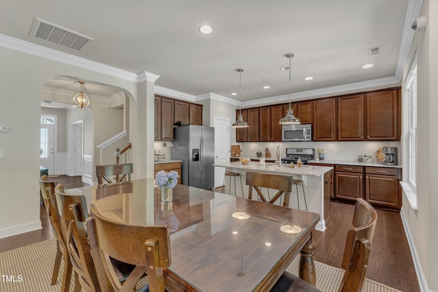 6509 Conaway Ct, Wake Forest, NC 27587 - dining space featuring arched walkways, dark wood-style floors, crown molding, recessed lighting, and baseboards