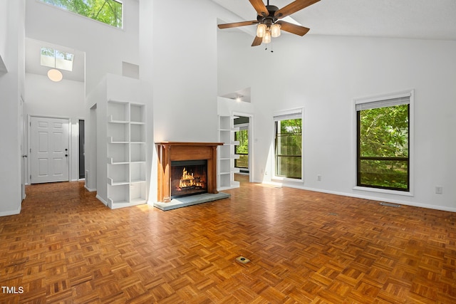 120 Polks Landing Rd, Chapel Hill, NC 27516 - unfurnished living room with a towering ceiling, baseboards, a ceiling fan, a lit fireplace, and built in shelves